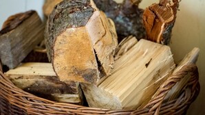 Een mand gevuld met blokken hout, waarschijnlijk voor brandhout.