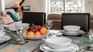 A dining table set with white plates, bowls, and a fruit bowl containing oranges and grapes. - 2 Bed in Fowey (oc-p00839) (Fowey)