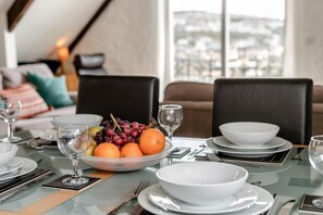 A dining table set with white plates, bowls, and a fruit bowl containing oranges and grapes. - 2 Bed in Fowey (oc-p00839) (Fowey)