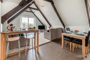 A loft-style room with a dining area, a sofa, and a television. - 2 Bed in Fowey (oc-p00839) (Fowey)