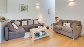 A modern living room with two sofas, a coffee table, and wall-mounted lighting. - 2 Bed in Llaniestyn (oc-gweger) (Llaniestyn)
