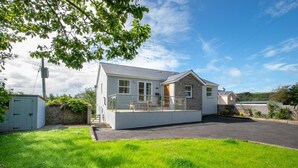 A two-story house with a balcony, a stone wall, and a grassy yard. - 2 Bed in Llaniestyn (oc-gweger) (Llaniestyn)