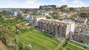 A residential building with a central courtyard, surrounded by greenery and other houses. - 2 Bed in St Ives (oc-gmn19) (Carbis Bay)