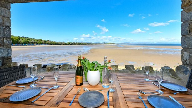 Mesa posta para dois com vista para a praia.