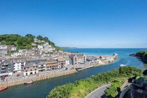 A coastal town with a harbor, buildings, and a clear blue sky. - 2 Bed in Looe (oc-l30069) (Looe)