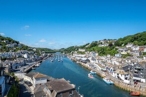 A coastal town with a river, boats, and buildings along the waterfront. - 2 Bed in Looe (oc-l30069) (Looe)