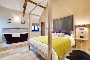 Ein Schlafzimmer mit Himmelbett, Badewanne und einem kleinen Fenster.