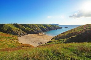 A coastal landscape with grassy hills, a sandy beach, and the sea. - 1 Bed in Aberdaron (oc-bow85) (Rhoshirwaun)