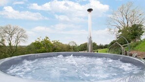 Un bain à remous extérieur, avec une structure cylindrique haute en arrière-plan.