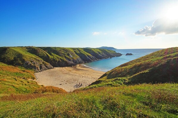 A coastal landscape with grassy hills, a sandy beach, and the sea. - 2 Bed in Aberdaron (oc-bow86) (Rhoshirwaun)