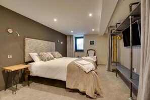A bedroom with a large bed, a bedside table, a chair, a TV, and a window with curtains. - 2 Bed in Aberdaron (oc-bow86) (Rhoshirwaun)