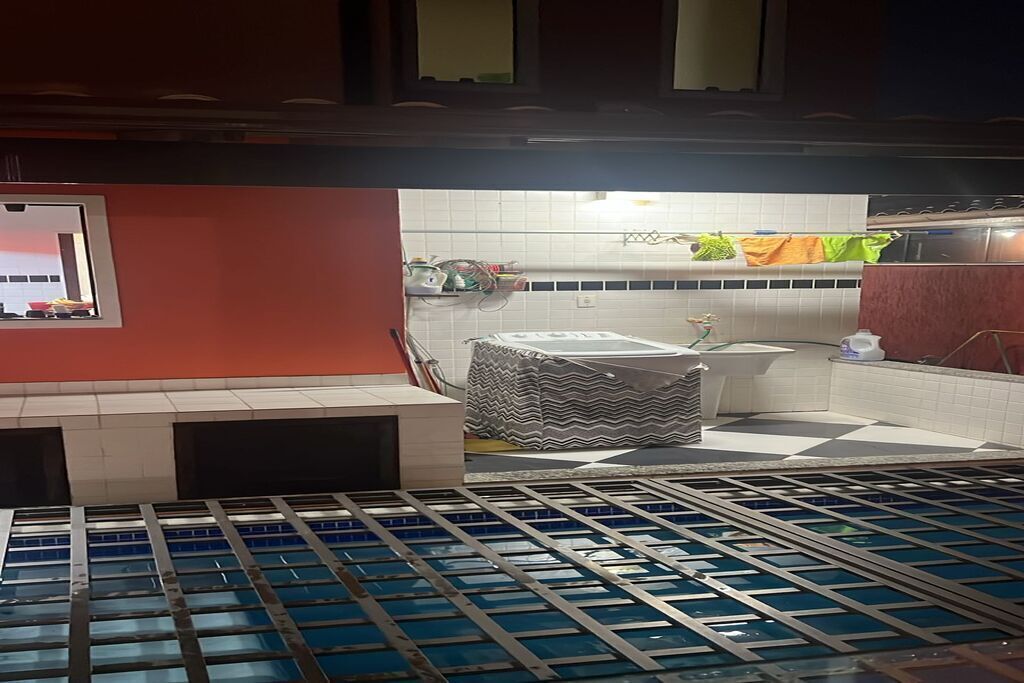 Une cuisine avec un mur recouvert de carreaux, un évier et un plan de travail.