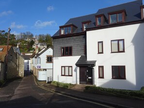 A narrow street with white buildings, one labeled 'Pioneer Cottages.' - 2 Bed in Beer (oc-jbpion) (Beer)