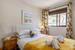 A hotel room with a bed, a bedside table with a lamp, a framed picture on the wall, and a window with curtains. - 2 Bed in Beer (oc-jbpion) (Beer)