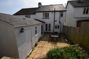 A residential property with a patio, a table, and chairs.