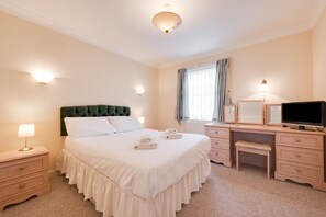 A hotel room with a bed, bedside tables, a desk with a chair, a television, and a window with curtains. - 2 Bed in Brighton (oc-bbivy2) (Hove)