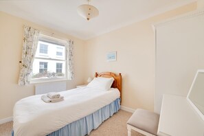 A bedroom with a bed, a window with curtains, a bedside table, a chair, and a picture on the wall. - 2 Bed in Brighton (oc-bbivy2) (Hove)