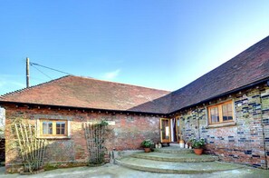 A brick building with a tiled roof, a small porch with steps, and potted plants. - 3 Bed in Rye (oc-rh1137) (Brede)