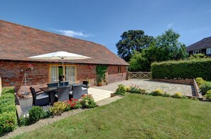 A brick house with a patio, outdoor seating, and a gated entrance. - 3 Bed in Rye (oc-rh1137) (Brede)