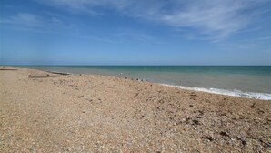 A pebbled beach with a wooden walkway leading to the water. - 2 Bed in Deal (oc-cc0163) (Kingsdown)