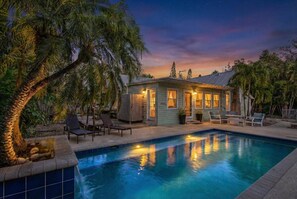A poolside area with a house, lounge chairs, and a palm tree. - Rustic Coastal Escape| Pool | Fire Pit (Bradenton)