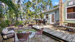 A patio area with wicker furniture, a grill, and a wooden deck. - Rustic Coastal Escape| Pool | Fire Pit (Bradenton)