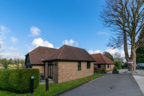 A brick building with a pitched roof, a paved driveway, and a well-maintained lawn. - 2 Bed in Wrotham (oc-ts732) (Stansted)