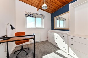 A bedroom with a wooden ceiling, a desk with a lamp, an orange chair, a dresser, and a window with a view. - 1 Bed in Pwllheli (oc-7marin) (Pwllheli)