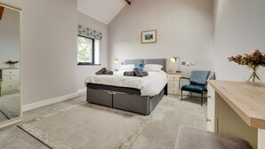 A bedroom with a bed, bedside tables, a desk, a chair, a window with curtains, and a hanging light fixture. - 1 Bed in Caernarfon (oc-bow270) (Penygroes)