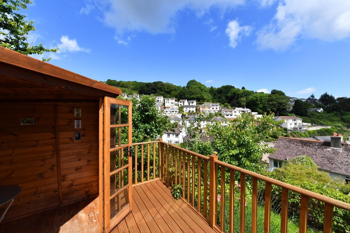 Eine Holzdar Terrasse mit Blick auf ein Hügel-Dorf.
