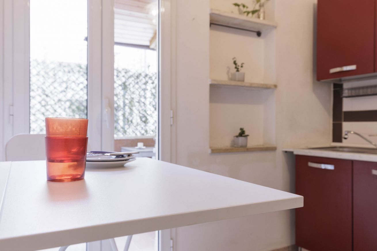 A white table with a glass of water and a plate.