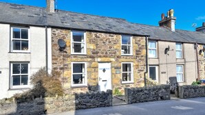 A stone building with multiple windows and a door, likely a pub or inn, with a stone wall and a paved road in front. - 3 Bed in Llanbedrog (oc-brntr) (Llanbedrog)