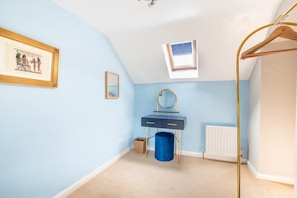 A room with a blue wall, a small window, a mirror, a blue trash bin, and a radiator. - 1 Bed in Elton (oc-dctco) (Elton)