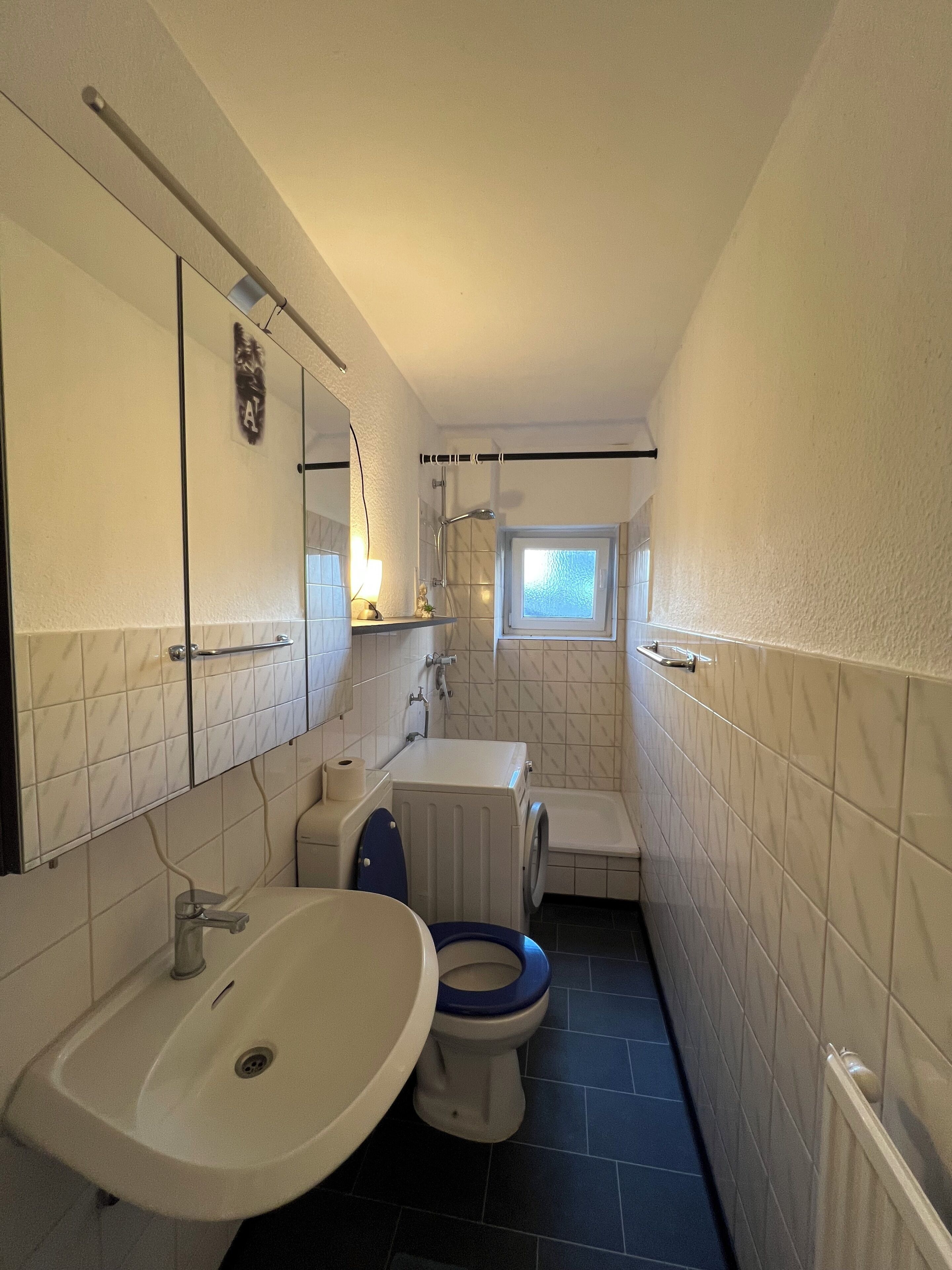 Un baño pequeño con lavamanos, inodoro y ducha.
