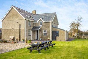 A two-story house with a stone exterior, a front door, and a visible window. - 4 Bed in Rhoshirwaun (oc-bow324) (Rhoshirwaun)