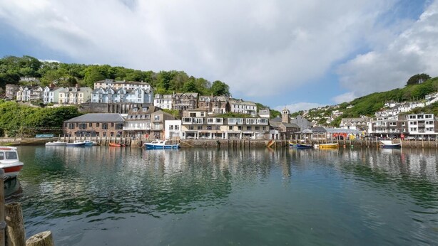 A waterfront town with buildings along the shore, boats docked, and a clear sky. - 1 Bed in West Looe (oc-1west) (Looe)