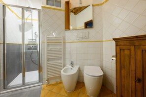 A bathroom with a glass shower enclosure, a bidet, and a toilet. - Sweet House in Macci Street (Firenze)