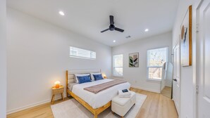 A bedroom with a bed, bedside table, nightstand, and a ceiling fan. - Modern Retreat • Private Pergola • Pool • Fire Pit (Houston)