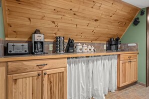 A kitchen with wooden cabinets, a coffee maker, a toaster, and a knife block.