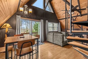 A cozy room with a dining table, chairs, a sofa, and a fireplace.
