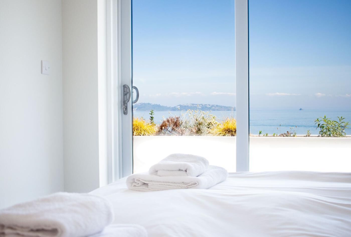 Une chambre à coucher avec un lit, une fenêtre et une vue sur la mer.