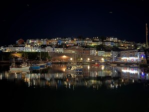 A coastal town at night with a marina, buildings, and a hilltop view. - 2 Bed in Brixham (oc-bh045) (Brixham)