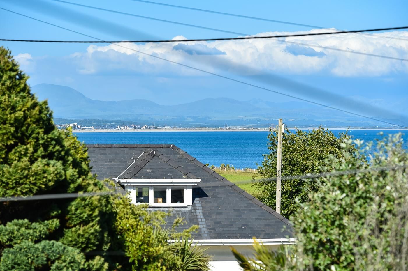 A residential area with a view of the sea and mountains in the background.