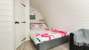 Une chambre à coucher avec un lit, une table de chevet, une chaise et une armoire.