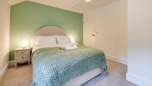 A bedroom with a bed, bedside table, and a hanging light fixture. - 6 Bed in Machynlleth (oc-bow374) (Glantwymyn)