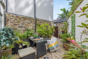 A stone wall, outdoor seating, and potted plants in a courtyard. - 1 Bed in Fowey (oc-saila) (Fowey)