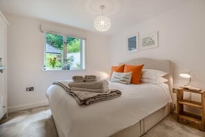 A bedroom with a bed, a window, a bedside table, and a lamp. - 1 Bed in Fowey (oc-saila) (Fowey)