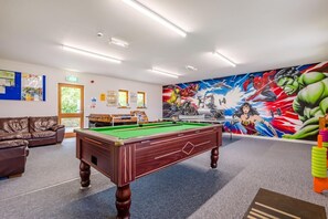 A pool table in a room with a mural of superheroes on the wall. - 2 Bed in Kilkhampton (oc-l27386) (Kilkhampton)