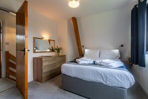 A bedroom with a bed, a dresser, a mirror, and a door. - 2 Bed in Kilkhampton (oc-l27386) (Kilkhampton)