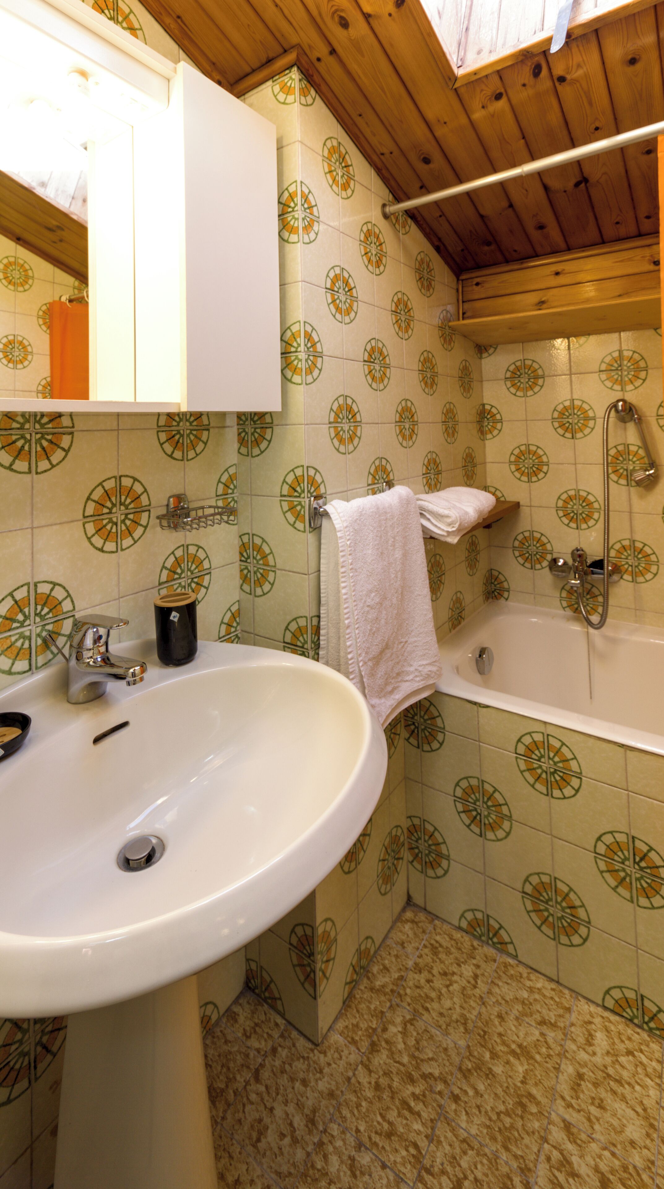 A bathroom with a sink, mirror, and bathtub.